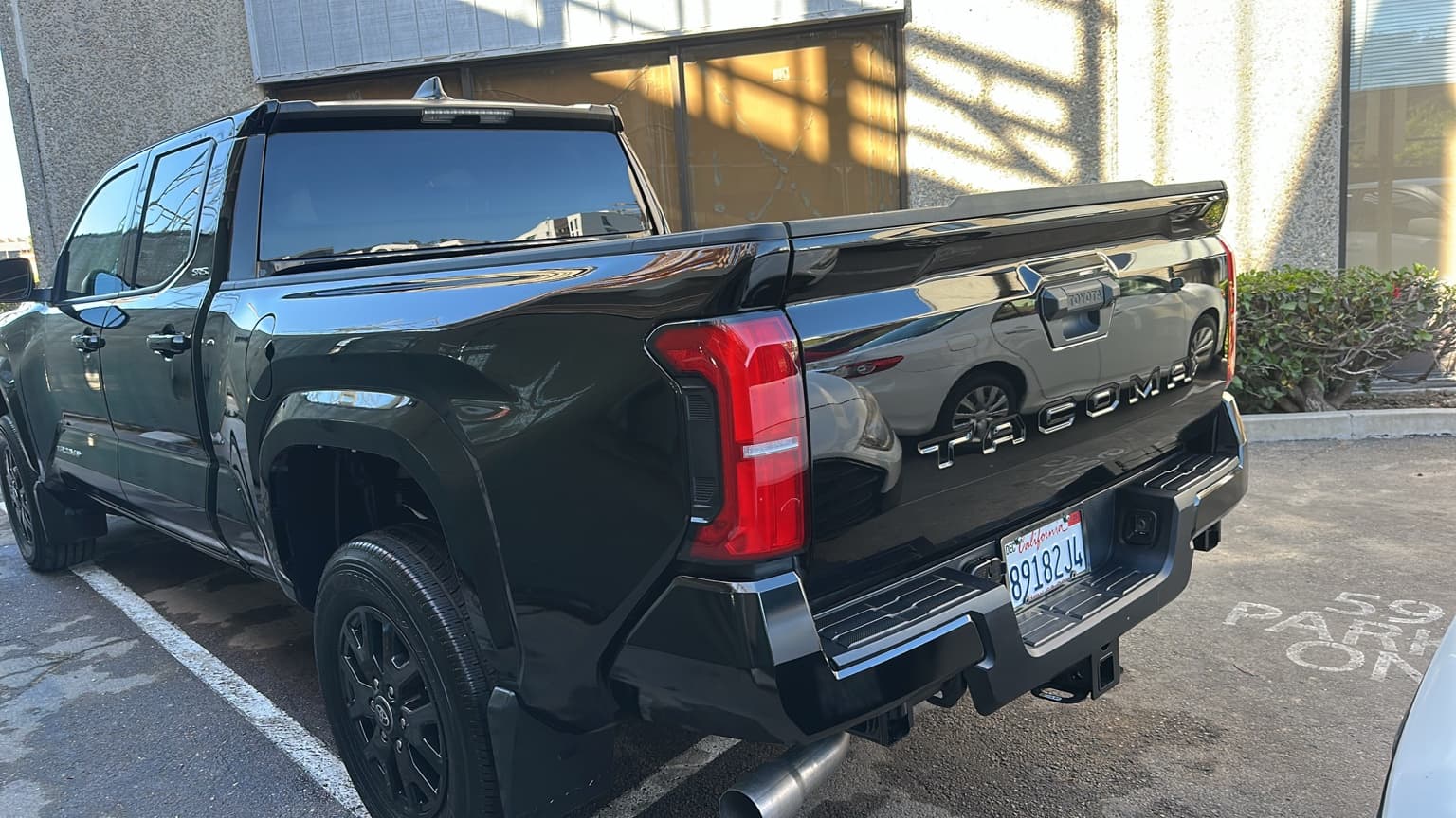 Glossy black Toyota Tacoma with clean paint and tires after an Exterior Detail